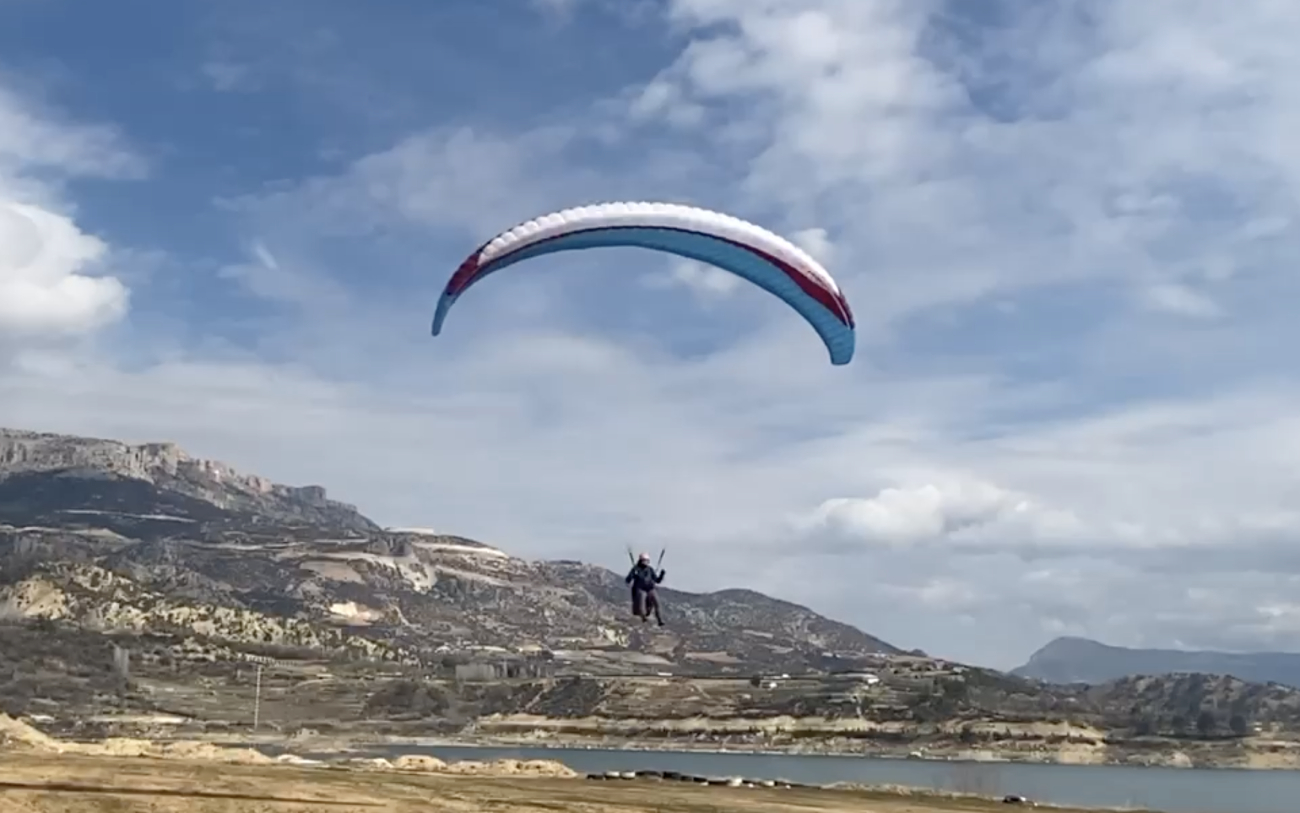 Ermenek'te paramotor eğitimi alan kursiyerlerin Toros Dağları manzarasında motorlu yamaç paraşütü ile uçuş anı